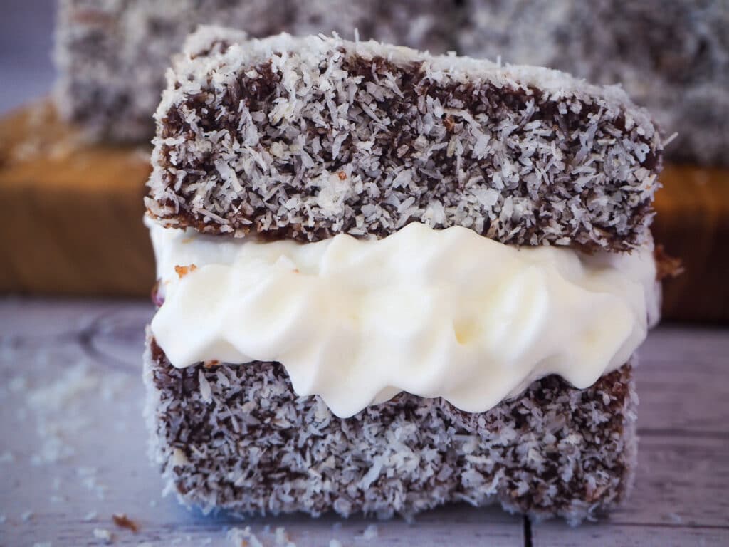 Lamingtons 37 Close up lamington filled with jam and cream.