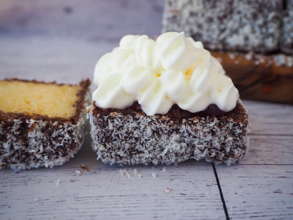 Lamingtons 36 Lamington with jam and cream and lid still open.