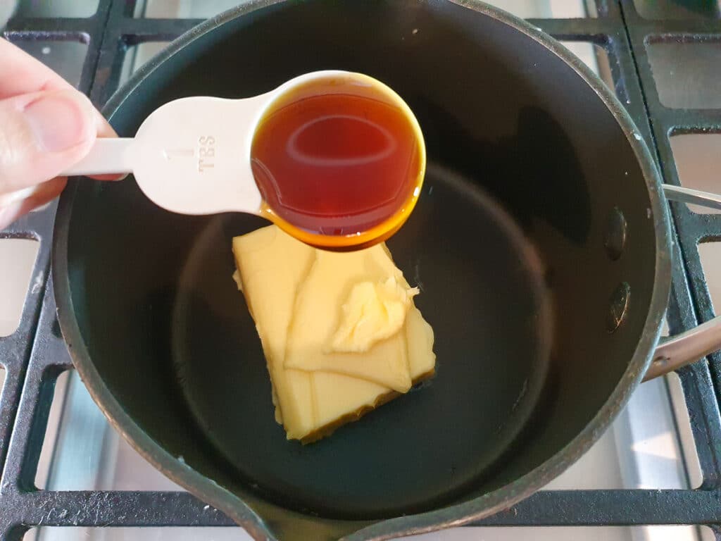 Ginger crunch 14 Adding golden syrup to pot on stove.