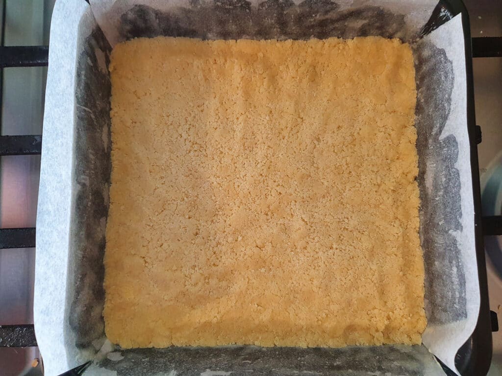 Ginger crunch 12 Base flattened down in tin ready to bake.