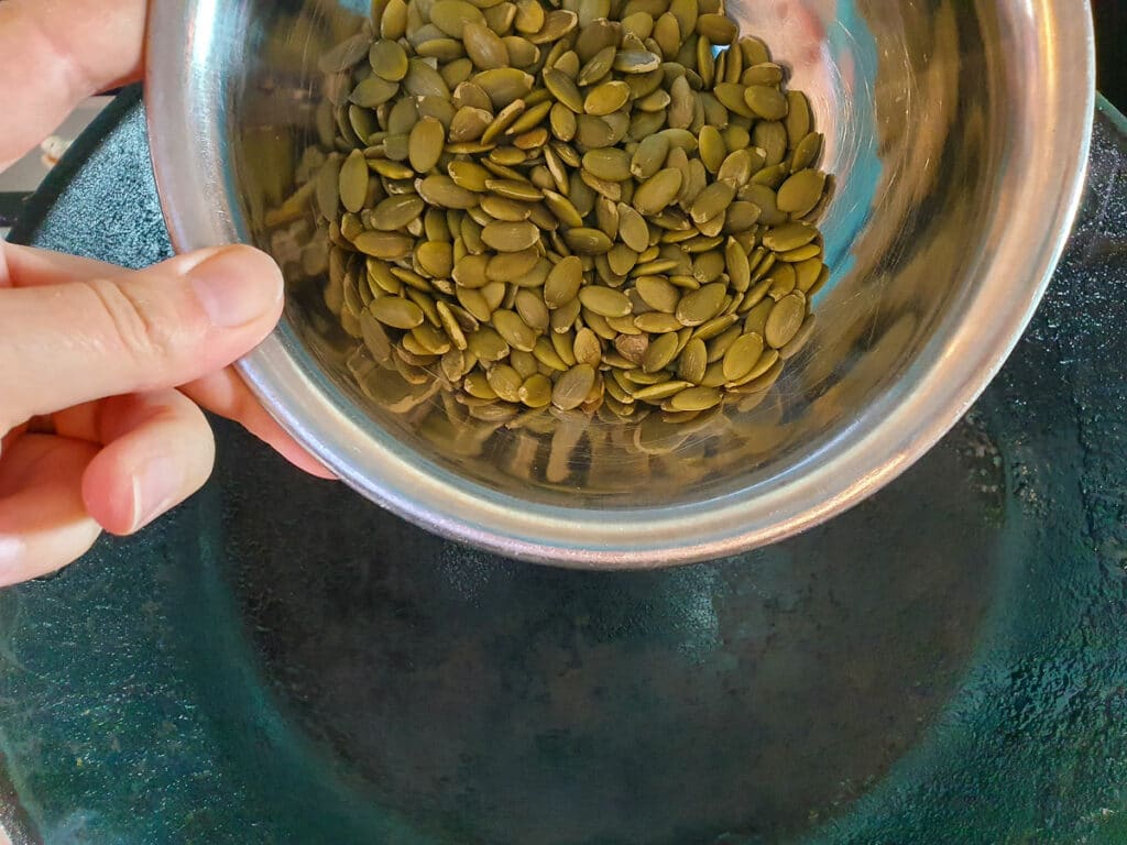Beetroot salad 3 Tipping pepitas into a hot dry frying pan.