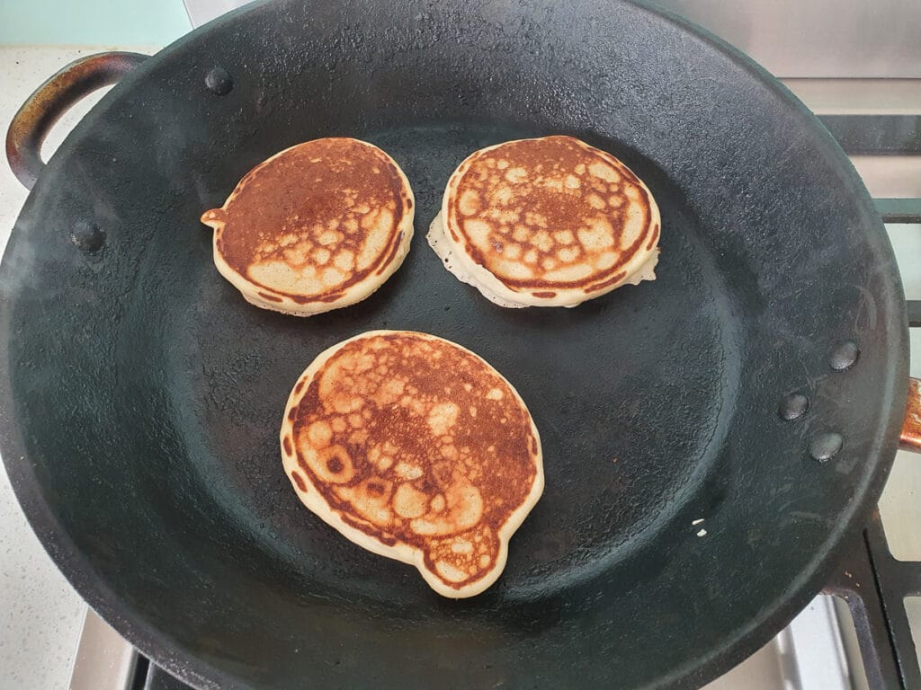 Pikelets 13 Cooking pikelets on other side in frying pan.