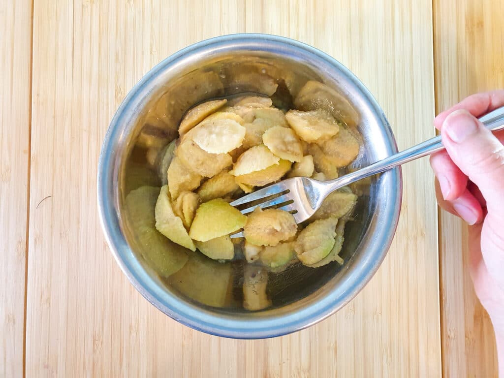 Feijoa muffins 5 Lightly mashing feijoa flesh with a fork.