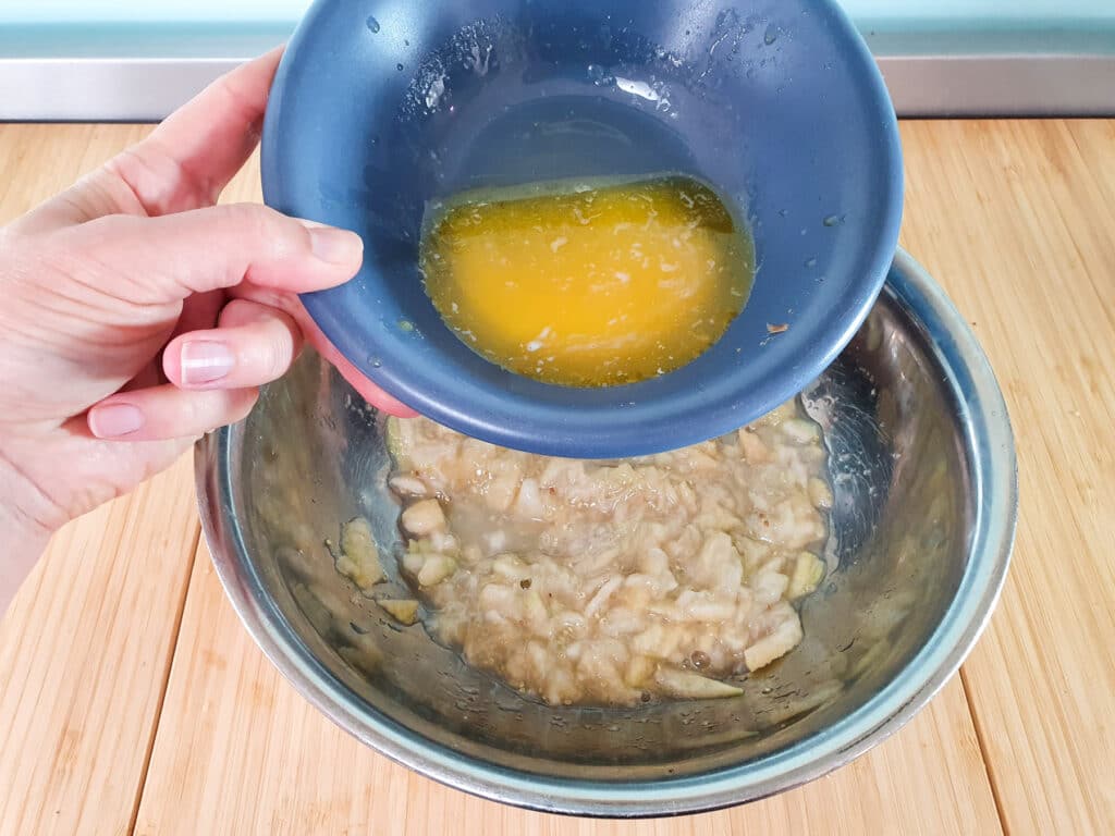 Adding melted butter to mashed feijoas.