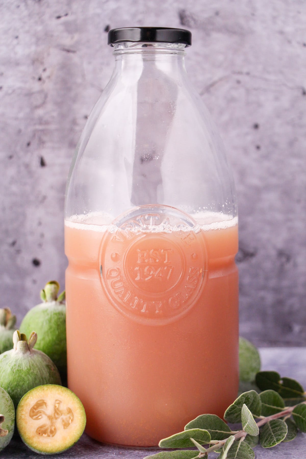 Feijoa syrup 14 Bottle of feijoa syrup withy fresh feijoas and leaves.