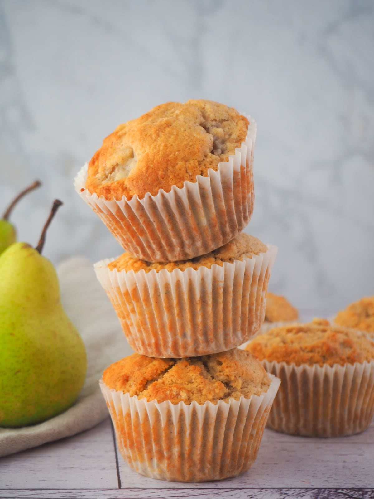 Pear muffins 17 Stack of pear muffins with fresh pears.