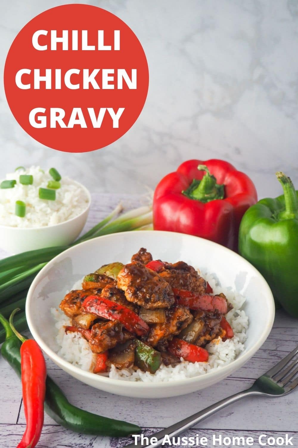 Chilli Chicken Gravy 25 Bowl of chicken on rice with fork and capsicums, spring onions and chilli on the side with text overlay, chilli chicken gravy and The Aussie Home Cook.
