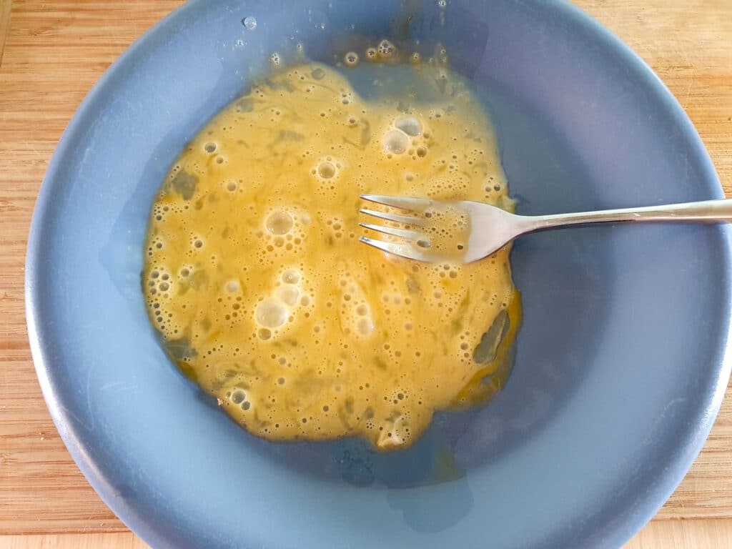 Chilli Chicken Gravy 11 Lightly beating egg on a plate.