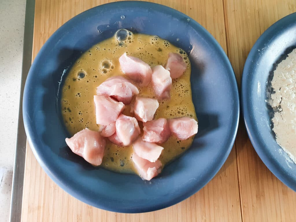 Chilli Chicken Gravy 13 Dipping chicken into egg wash.