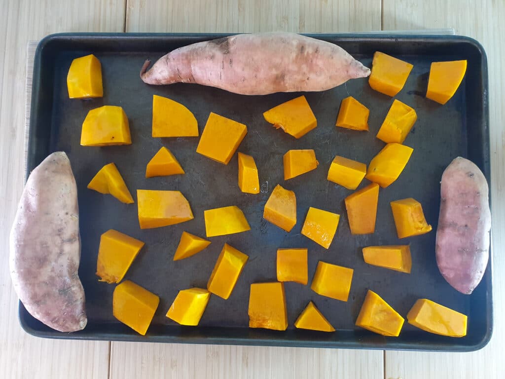 Pumpkin and Sweet Potato Soup 5 Putting the whole sweet potato and oiled pumpkin chunks onto a baking tray to roast.