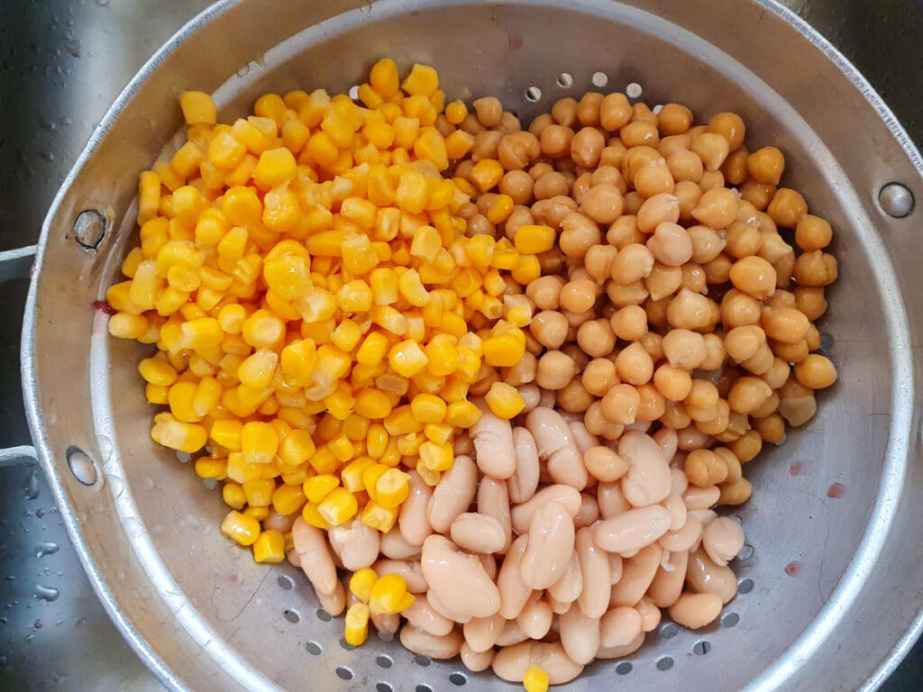 Four Bean Salad 8 Draining tinned corn kernels, kidney beans, butter beans and chickpeas well and rising.