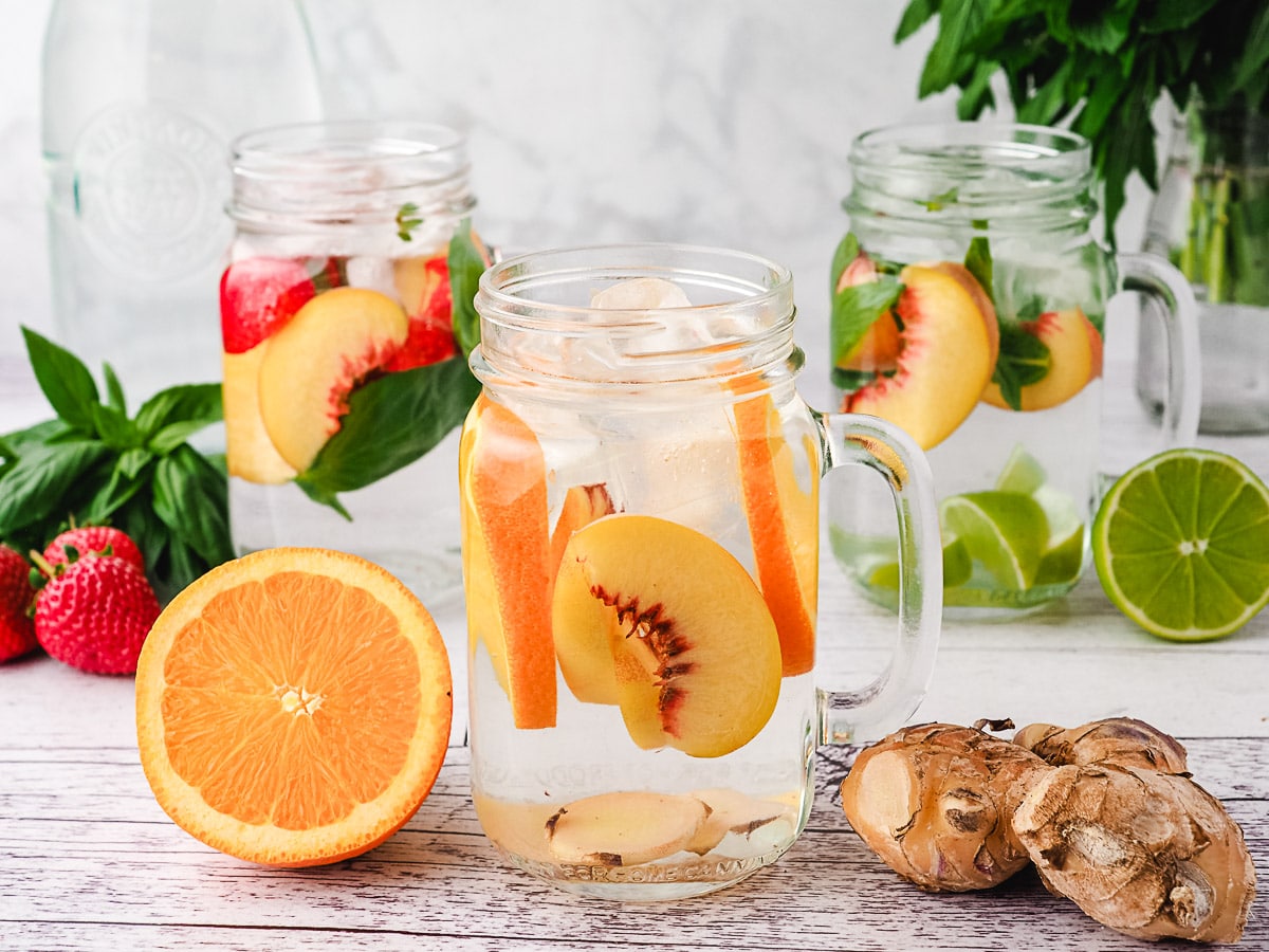 Peach Water 7 Peach infused water with strawberry and basil, with lime mint mixins and orange ginger mixins in background.